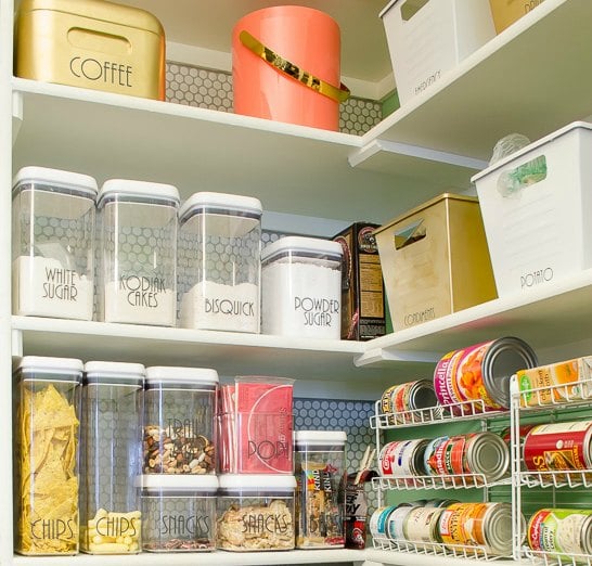 Organized pantry with clear food storage containers and can racks