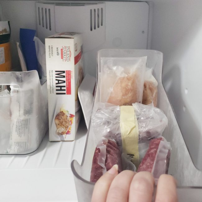 Meat in clear bin in freezer