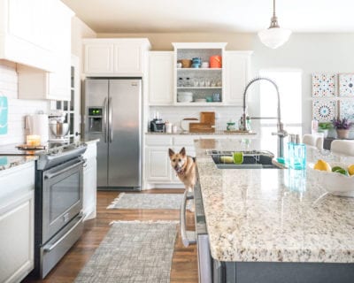 White kitchen with aqua accents, dark island, and granite