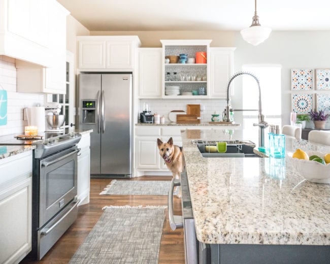 White kitchen with aqua accents, dark island, and granite