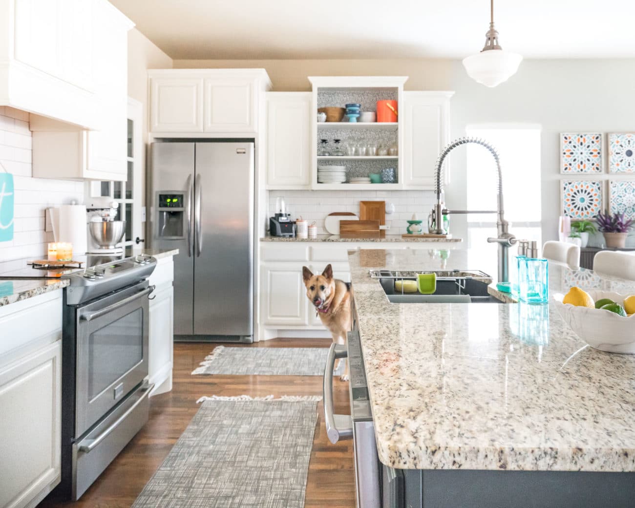 White kitchen with aqua accents, dark island, and granite