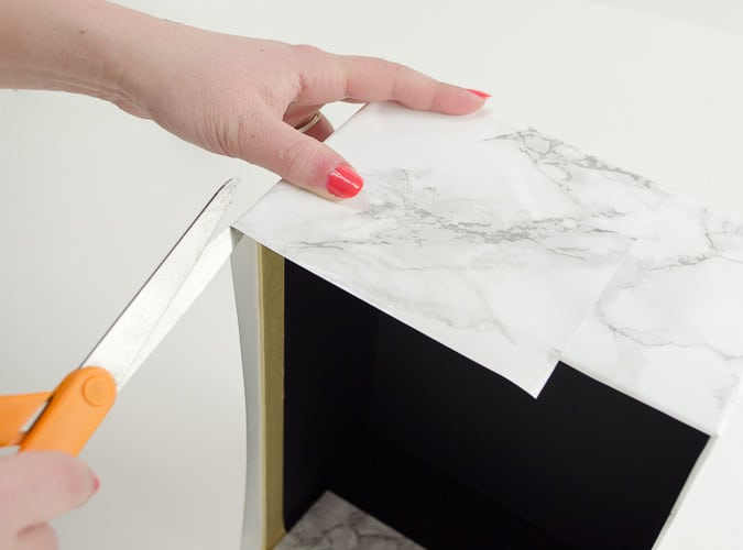 Marble contact paper plus an inexpensive photo box can be combined into inexpensive chic storage. Love the tips on how to make the corners look good! 