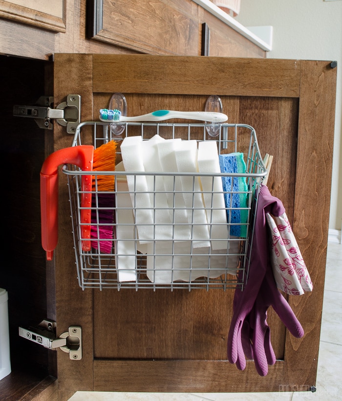 Love this idea for the bathroom! Use a basket to hold cleaning tools on the cabinet door.