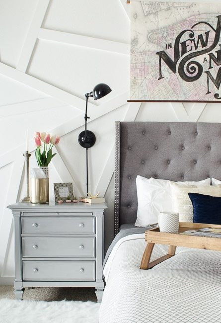 This silver nightstand was a DIY that works perfectly in this modern master bedroom. Love that gray tufted headboard!