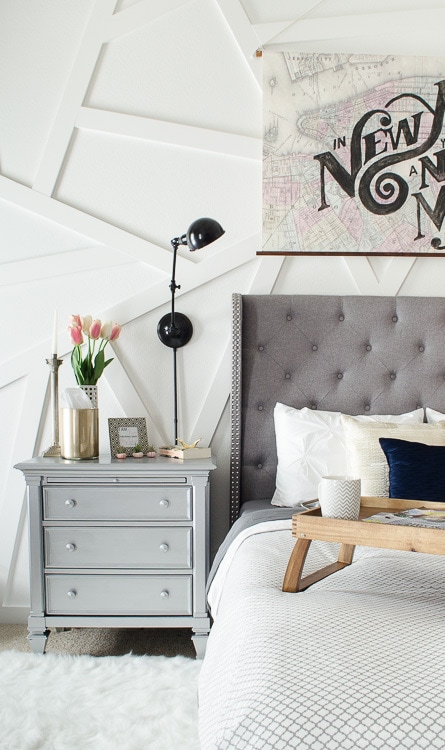 This silver nightstand was a DIY that works perfectly in this modern master bedroom. Love that gray tufted headboard! 