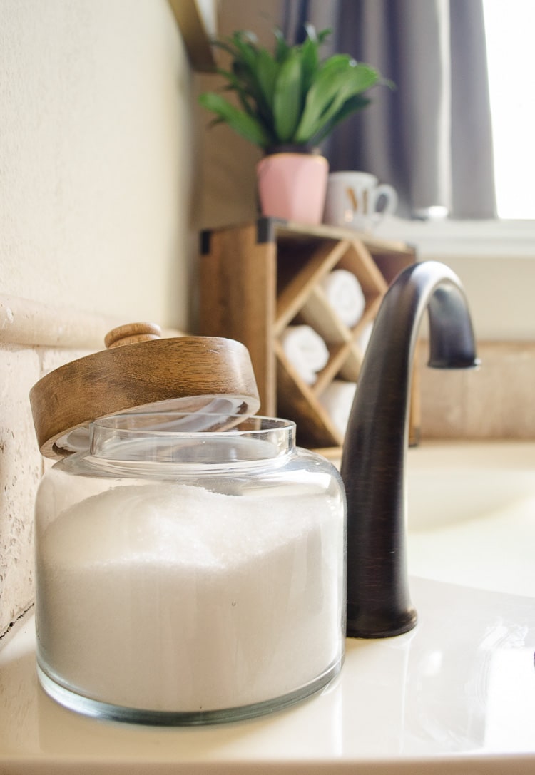 A kitchen canister is a great way to keep bath salts handy on the tub. Click for more pretty organizing ideas for the master bathroom!