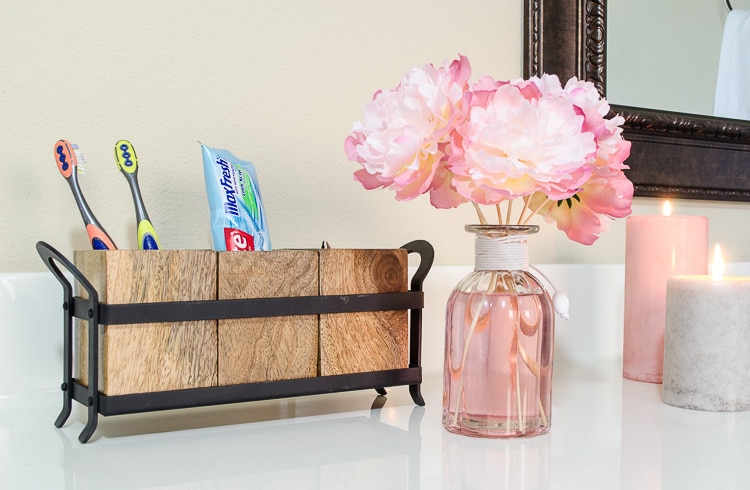 Think outside the box for bathroom storage - this cute toothbrush holder is actually a utensil holder from Pier 1.