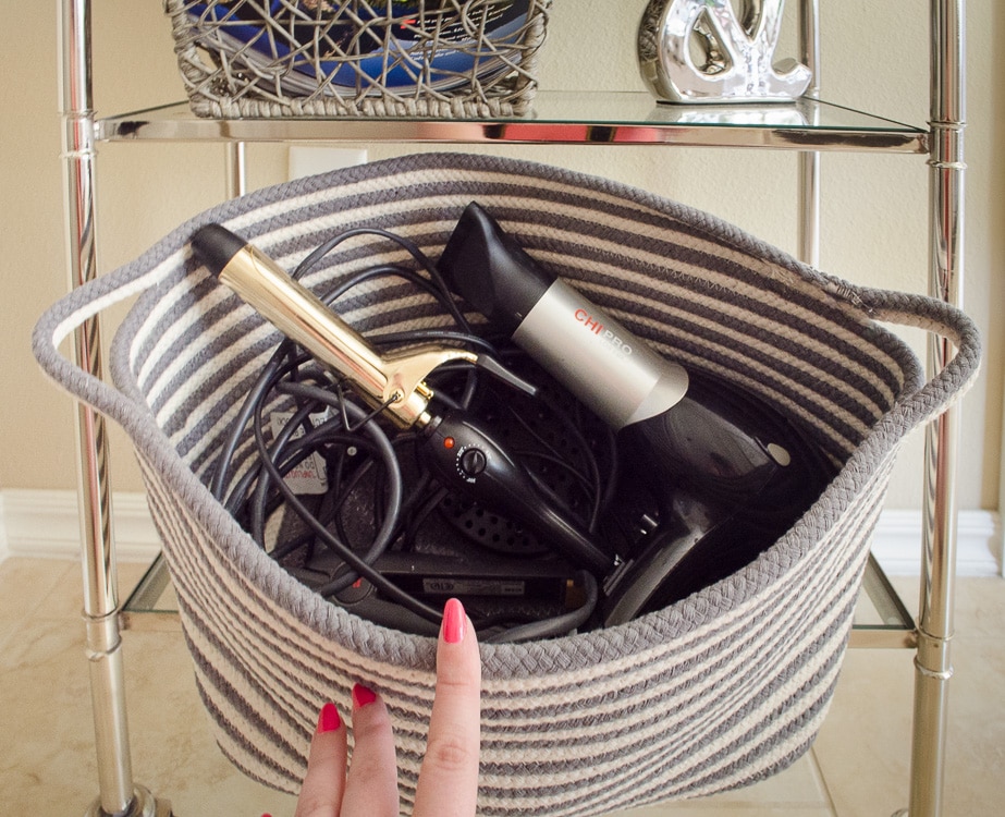 LOVE THIS! Get a basket for the blow dryer and straighter to hide the mess of cords out of sight in the bathroom. Click for more bathroom organizing ideas!