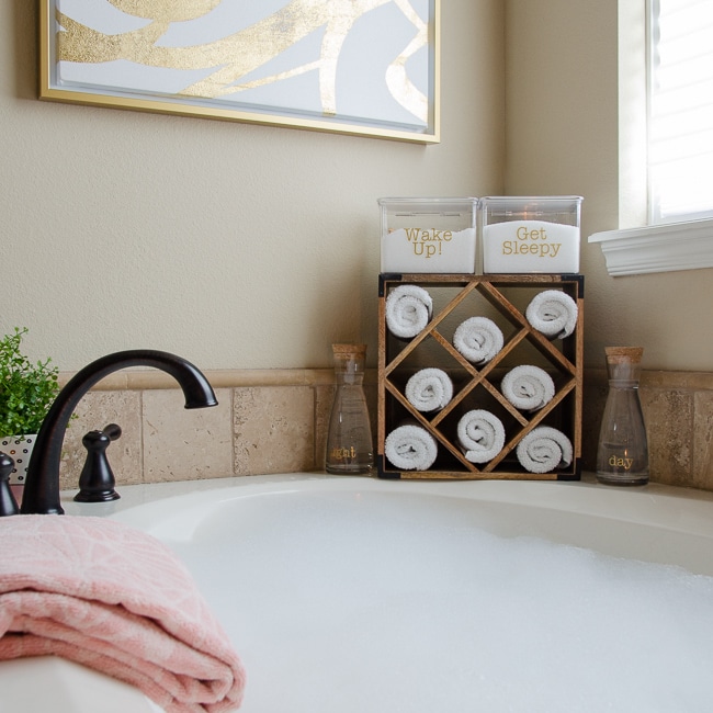 Garden bathtub with washcloths rolled in a wood wine rack