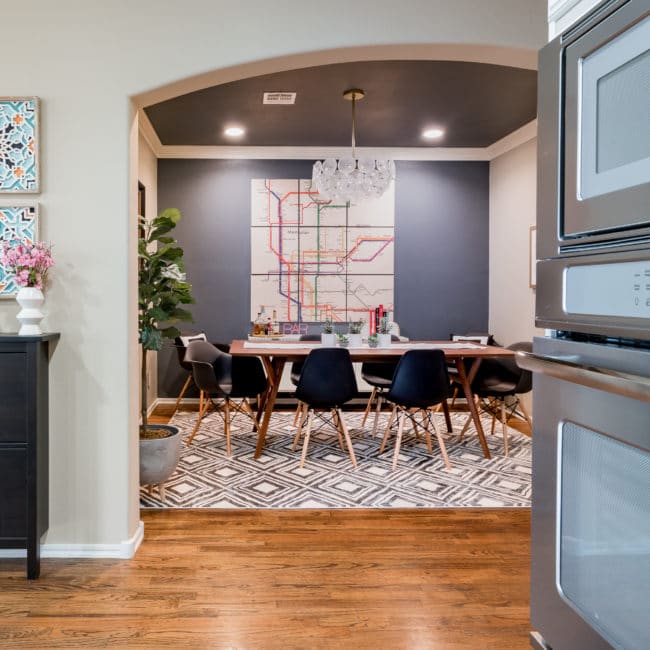 mid-century modern dining room with large wood map art on dark wall