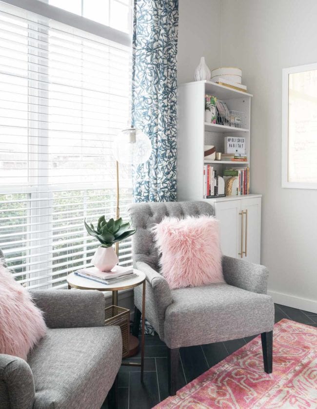 Office with grey chairs, pinks accents, and white bookcase