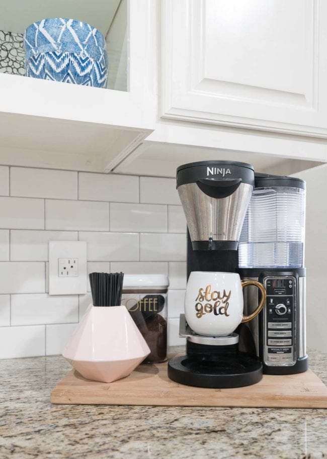 Ninja Coffee Bar in small coffee station with stir straws in pink vase. 