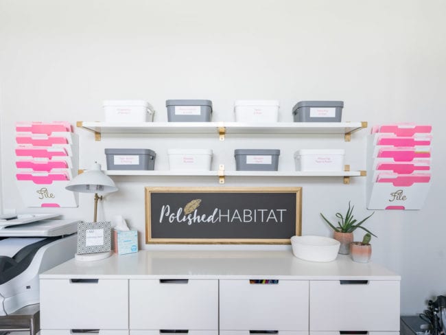 Open shelves with organized bins in white office 