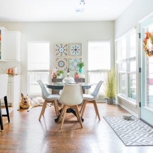 Eat in kitchen nook with aqua door, pops of orange and white modern chairs from Amazon.