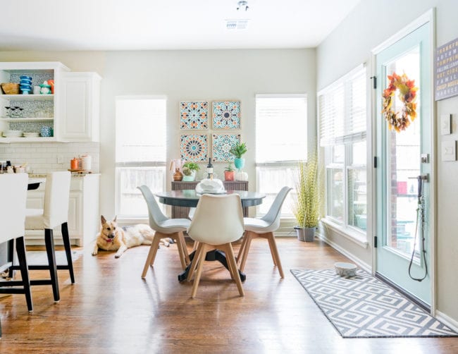 Eat in kitchen nook with aqua door, pops of orange and white modern chairs from Amazon. 