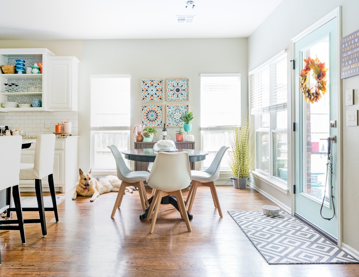 Eat in kitchen nook with aqua door, pops of orange and white modern chairs from Amazon.