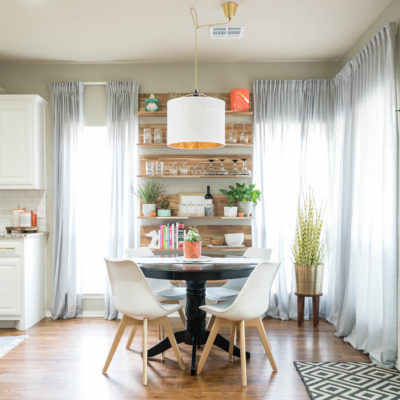 Dining nook with white modern chairs and IKEA Skogsta wood wall shelve