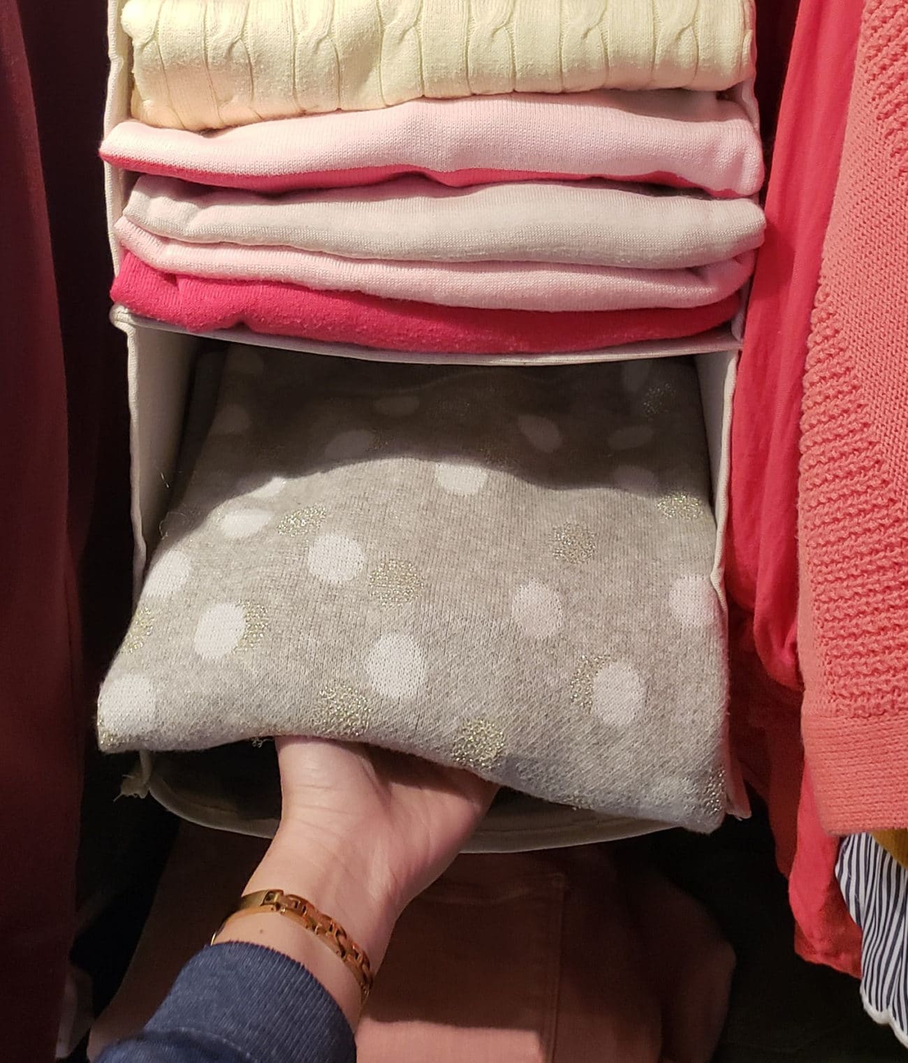 Organized sweaters in a closet