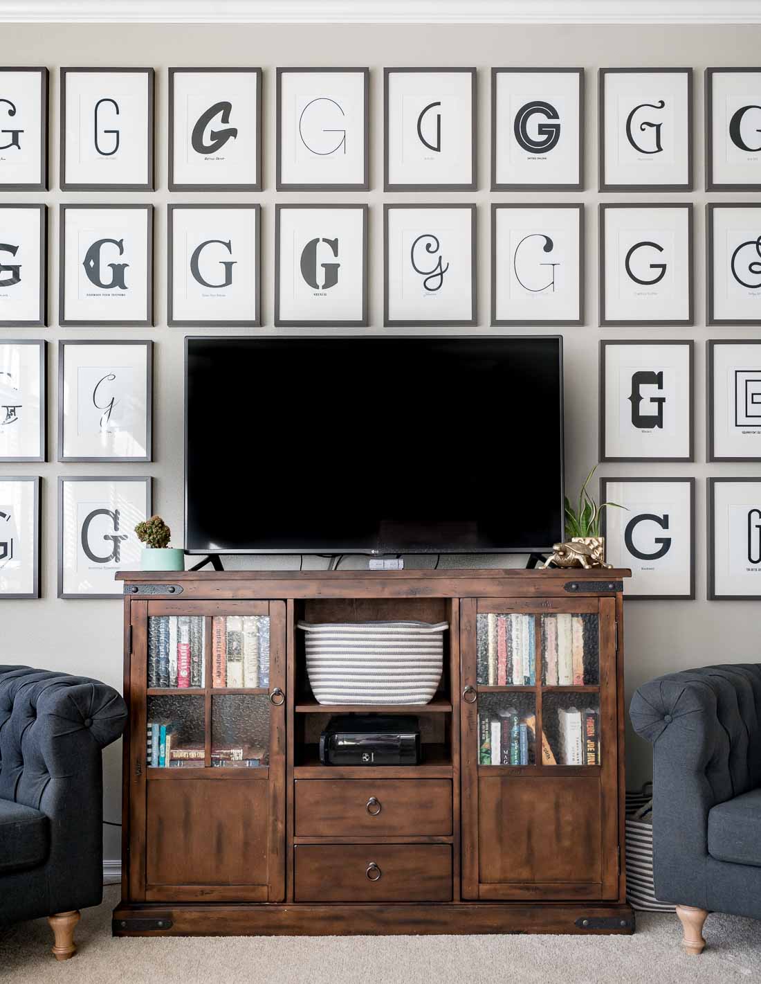 TV on wood console surrounded by typography G art 