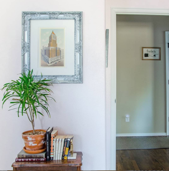 Books and tall plant on small wood table