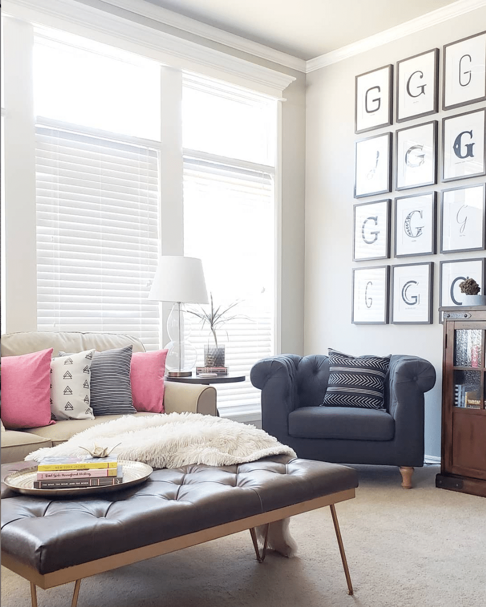 Transitional living room with leather tufted ottoman, bright pillows and chesterfield chair.