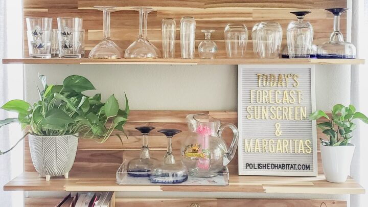 Wood kitchen shelves with glassware and white letter board with gold letters saying "Today's Forecast: Sunshine & Margaritas"