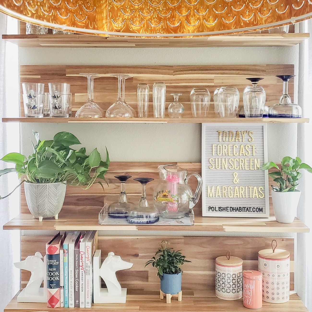 Wood kitchen shelves with glassware and white letter board with gold letters saying "Today's Forecast: Sunshine & Margaritas"