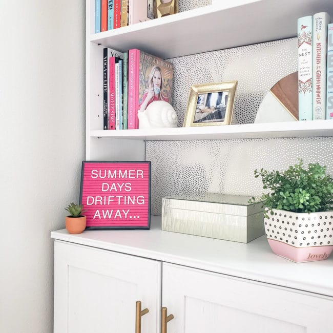 Close up of White bookcase with pink letterboard that says Summer Days Drifting Away