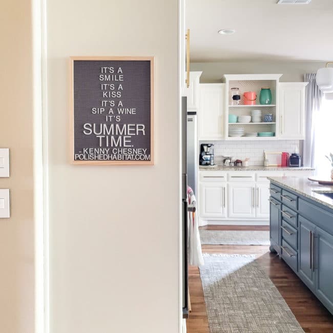 Gray letterboard in modern traditional white kitchen w/ gray island