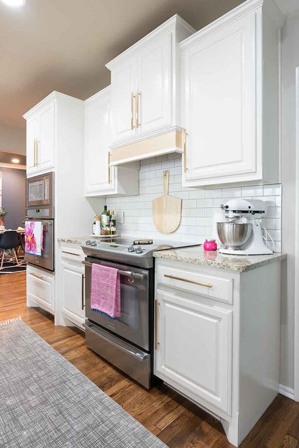 White kitchen with gold hardware and pink accents