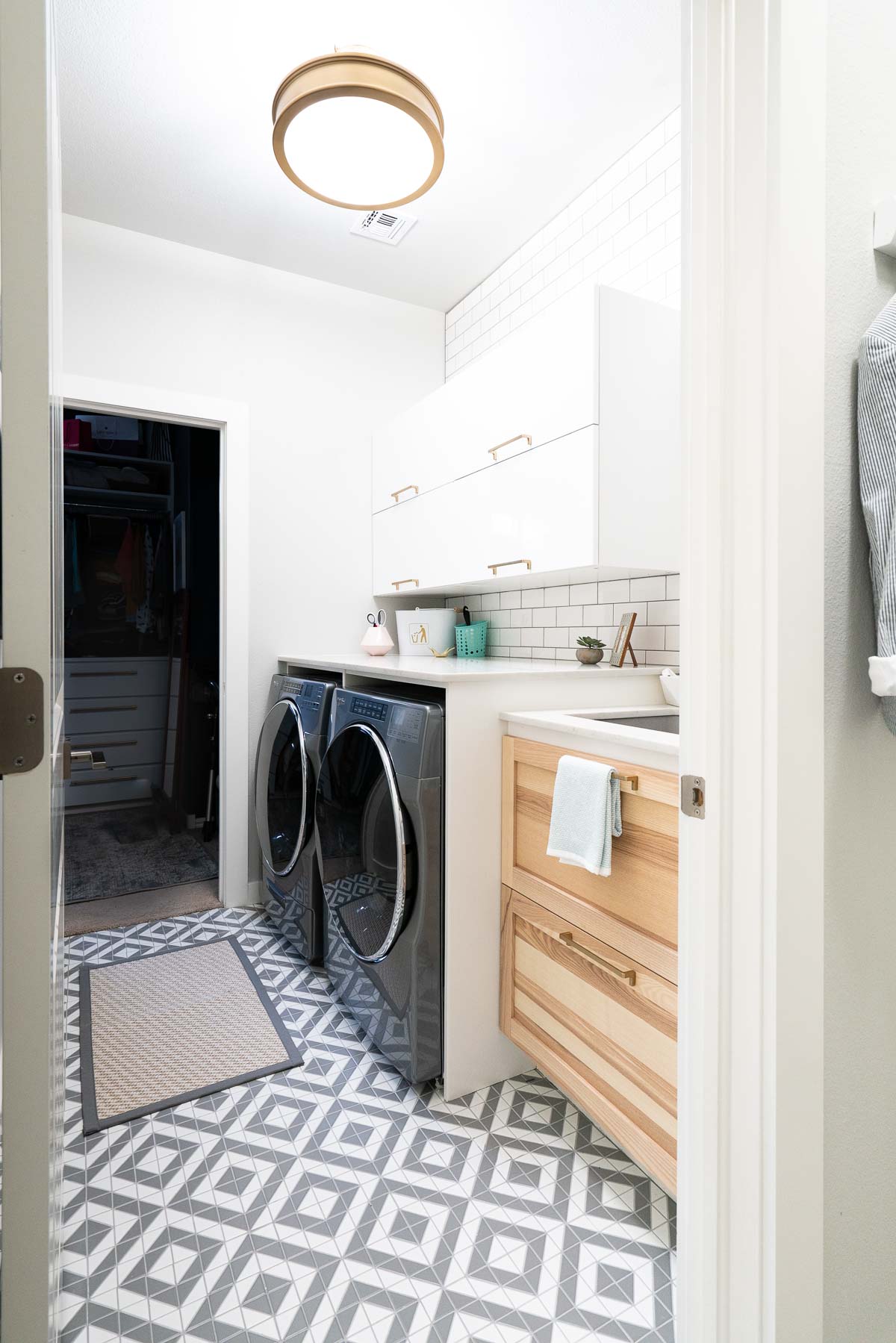 Small Laundry room with marble countertop and sink and wood cabinet
