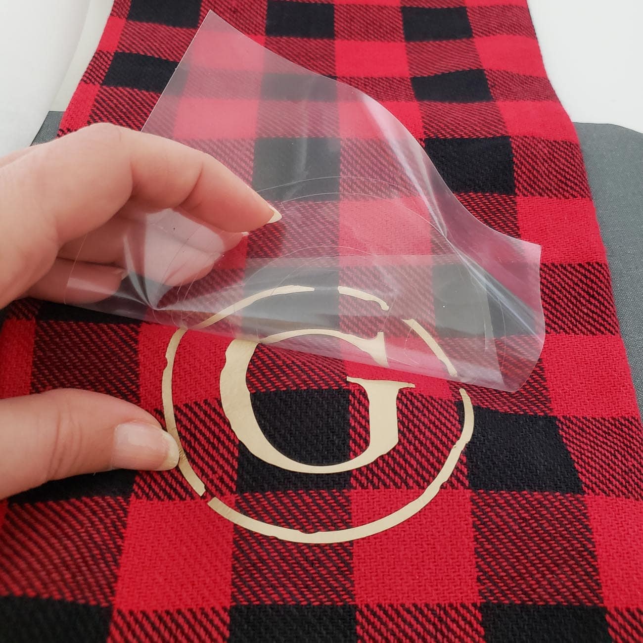 Applying a gold vinyl G to a buffalo check dish towel