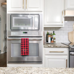 Red & Black buffalo check kitchen towel on stainless steel wall oven