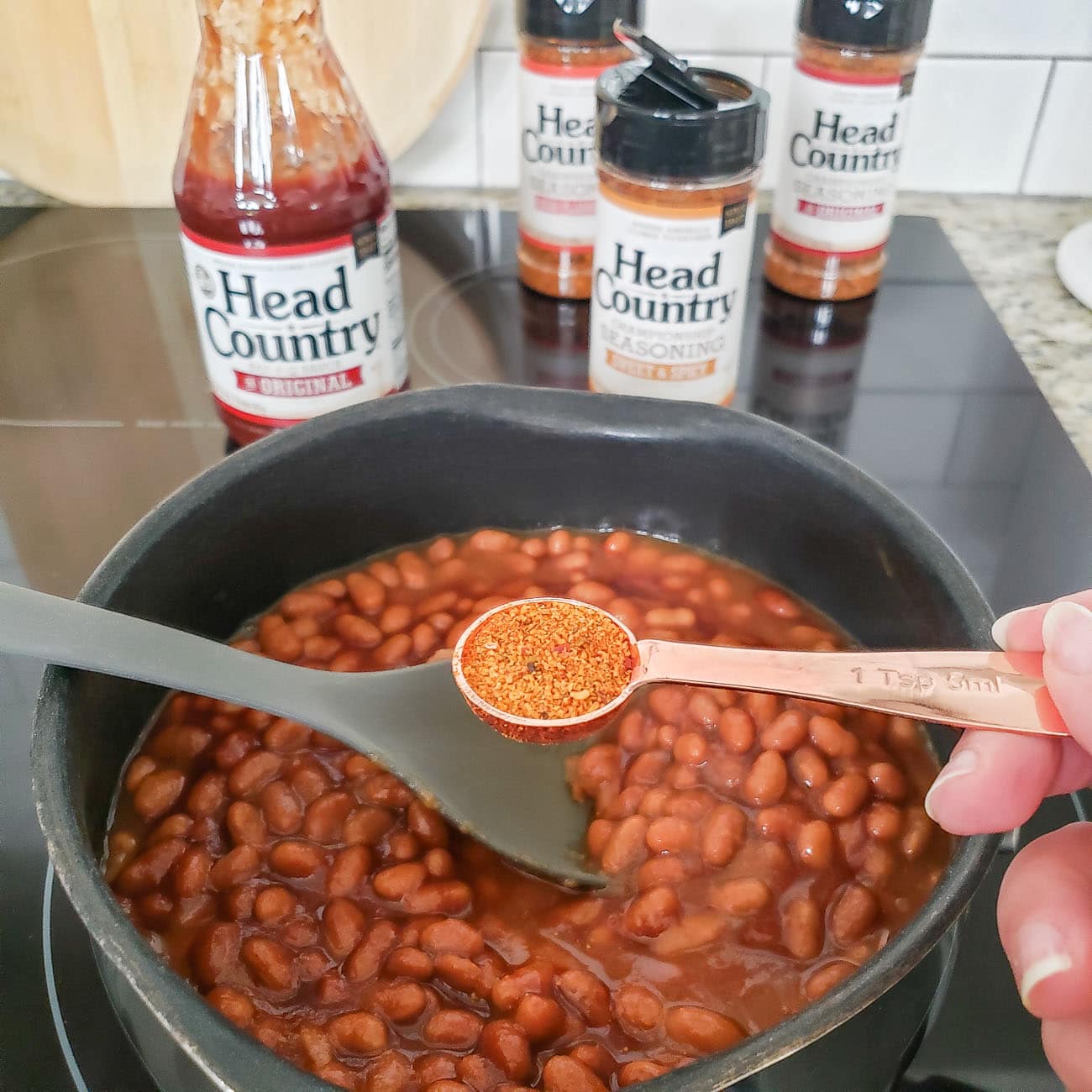 Head Country seasoning being added to baked beans