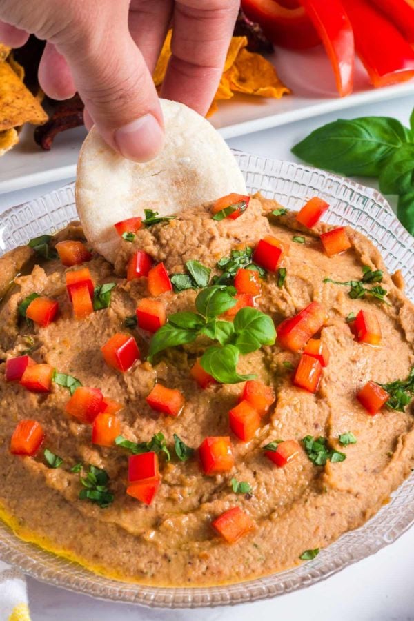 Pita bread dipping into hummus