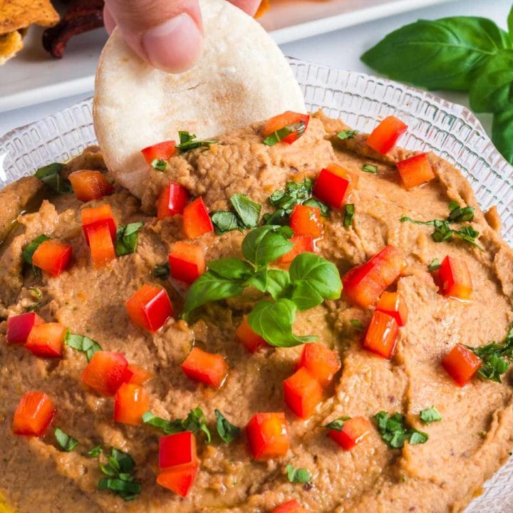 Pita bread dipping into hummus