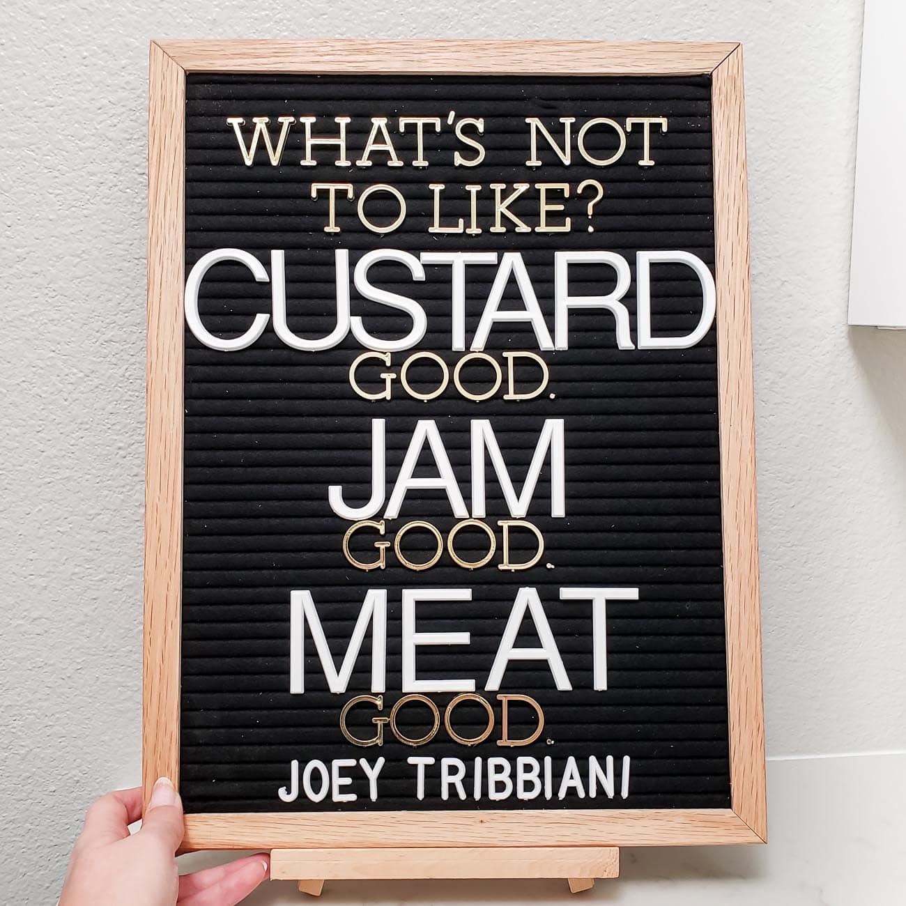 Quote from Friends TV Show - What's Not to Like? Custard, Good. Jam Good, Meat Good. On black letterboard. 