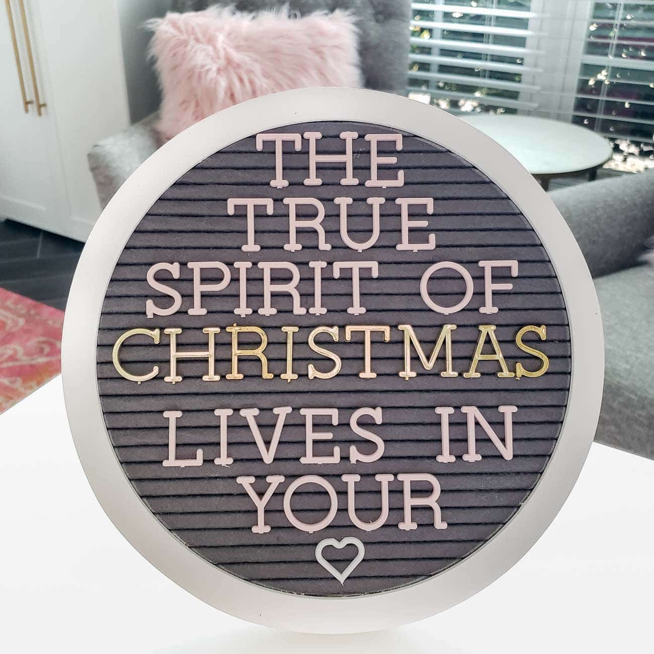 Round letter board with gray felt and white frame. 