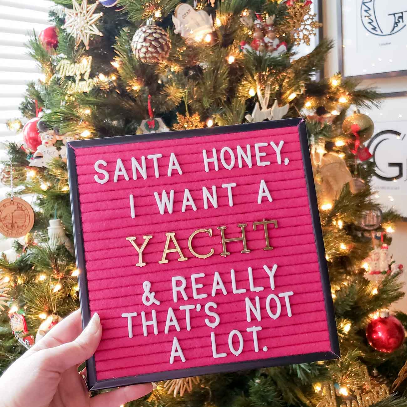 Pink letter board in front of Christmas Tree