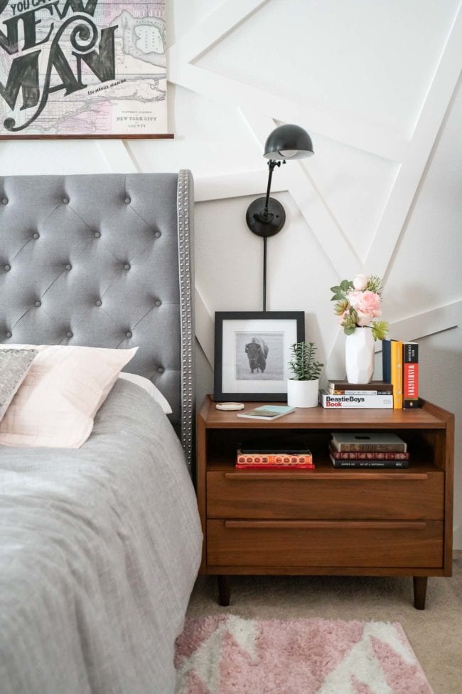 tall gray tufted headboard with wood nightstand