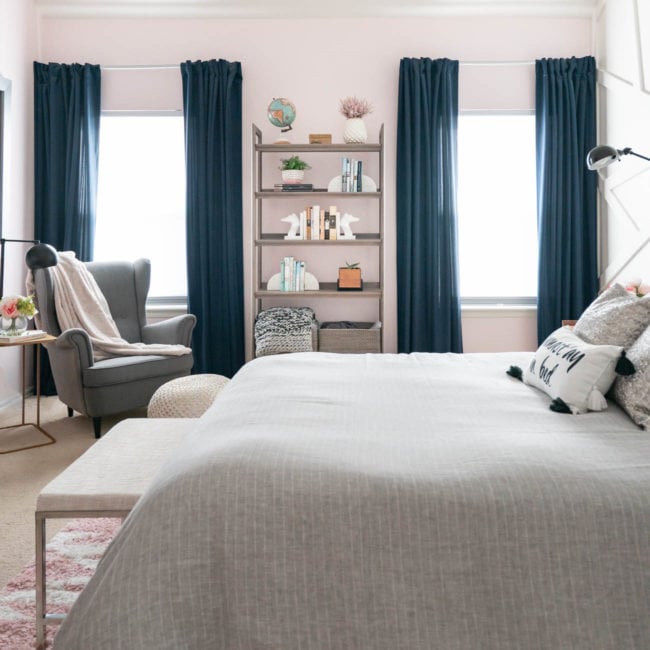 bedroom with two windows - navy drapes and gray bedding with pink walls