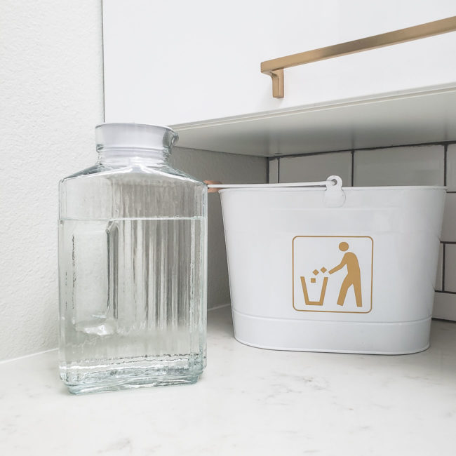 Glass jar of vinegar in white laundry room