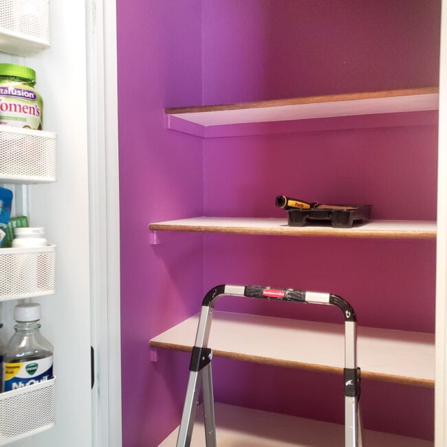 Empty white shelves in purple closet