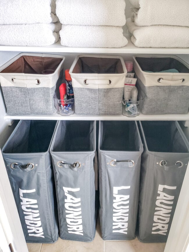 4 Grety tall laundy baskets under bottom shelf of linen closet