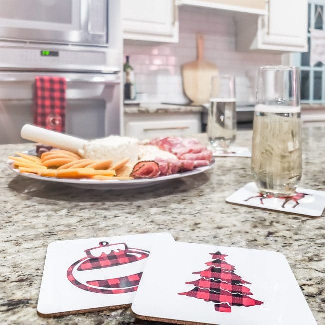 white coasters with buffalo check tree and ornament on granite kitchen counter