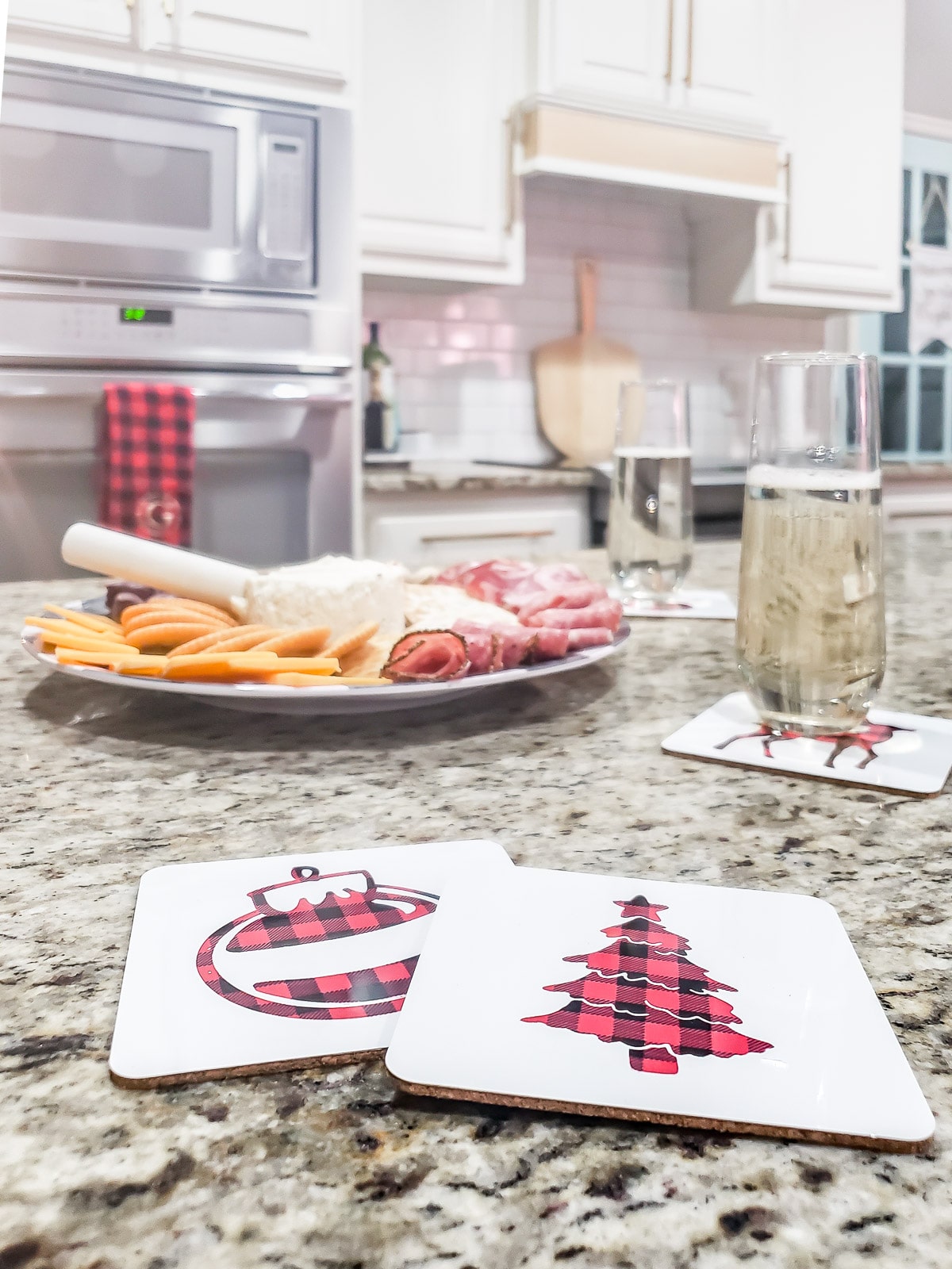 white coasters with buffalo check tree and ornament on granite kitchen counter