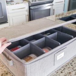 Grey divided container holding candles on kitchen counter