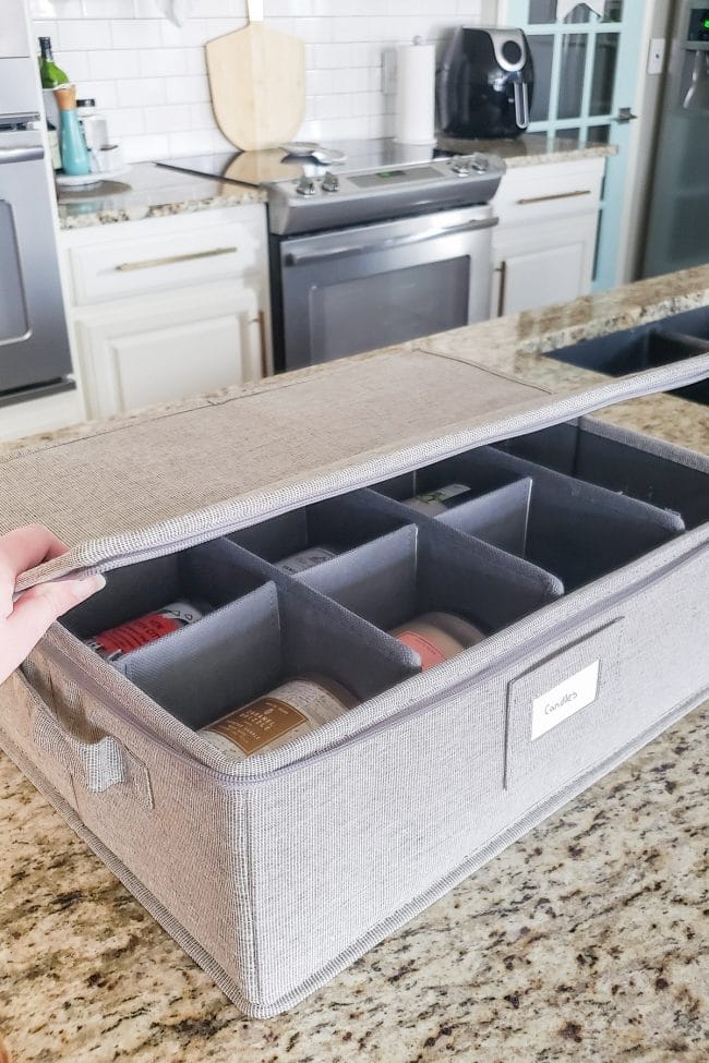 Grey divided container holding candles on kitchen counter