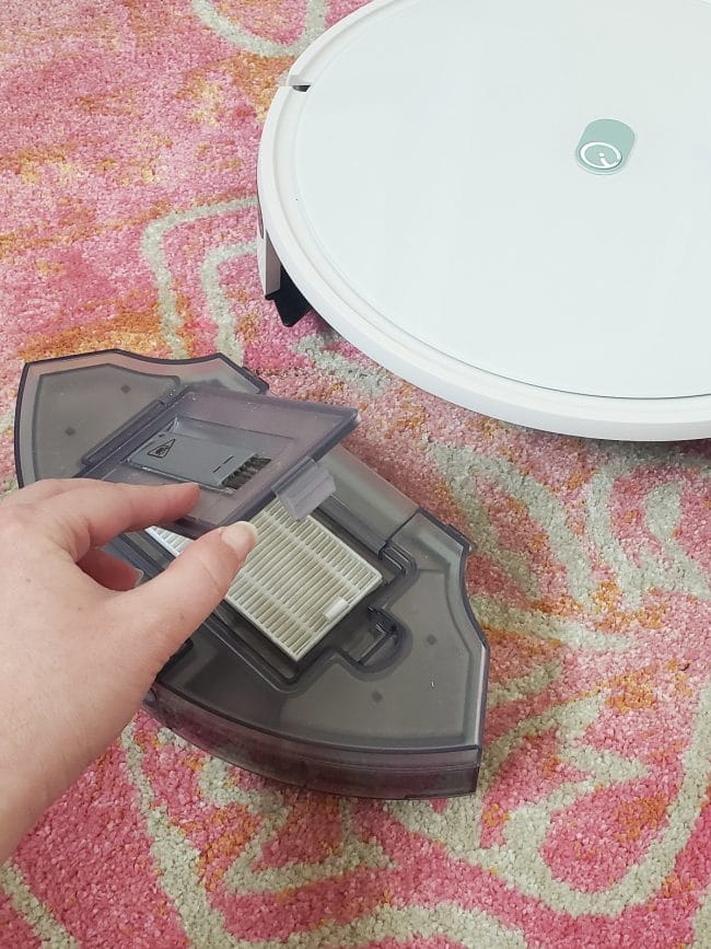 opening gray flap in plastic container to expose vacuum filter