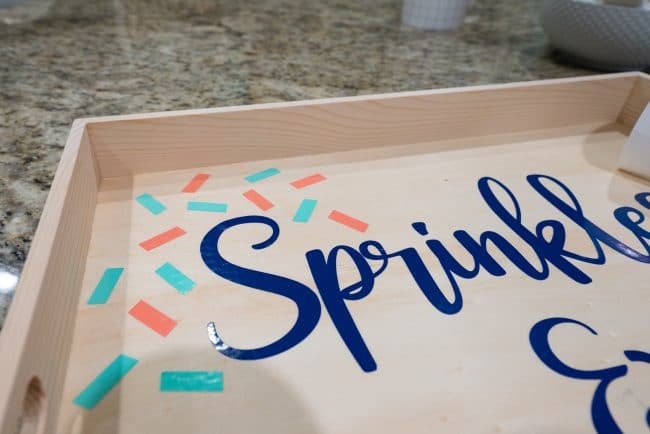 Close up of wood tray with teal and coral sprinkles made from vinyl